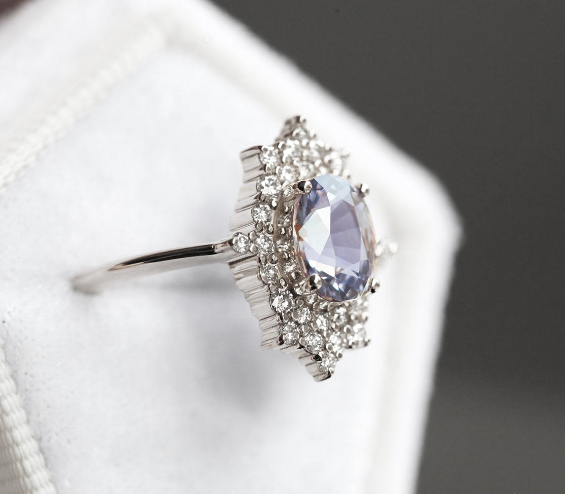 Oval-shaped lavender sapphire ring with diamond halo