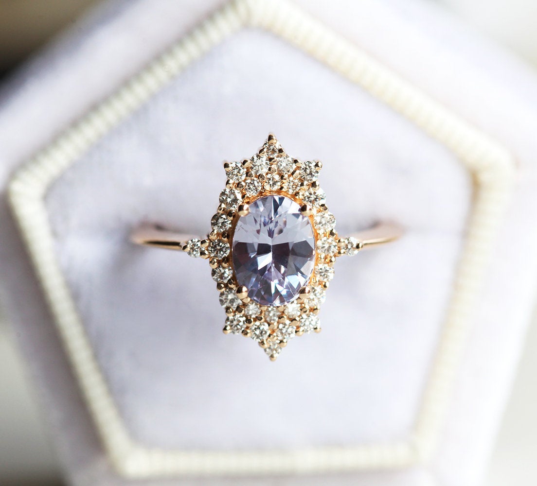 Oval-shaped lavender sapphire ring with diamond halo