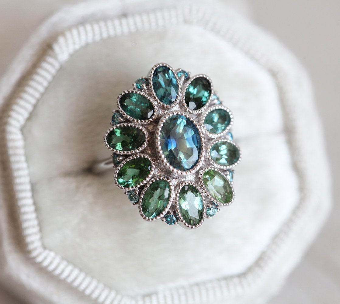 Oval-shaped teal sapphire cluster ring with torumaline and blue diamond stones