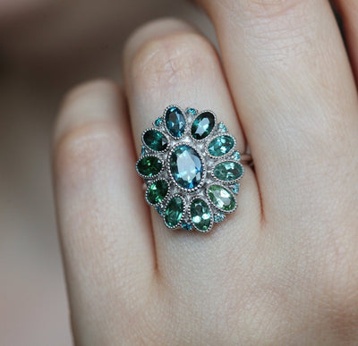 Oval-shaped teal sapphire cluster ring with torumaline and blue diamond stones