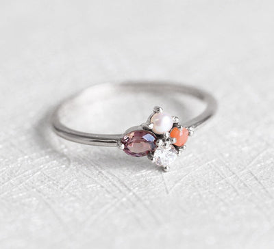 Oval-shaped peach sapphire cluster ring with diamond and coral stones