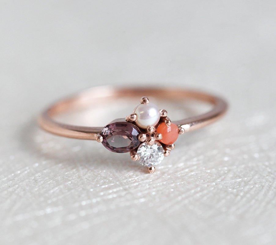 Oval-shaped peach sapphire cluster ring with diamond and coral stones