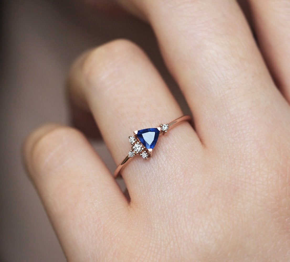 Blue triangle-cut sapphire ring with white diamond cluster