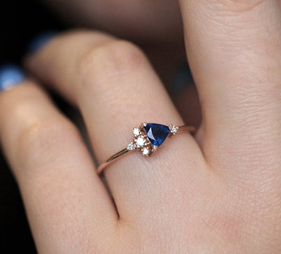 Blue triangle-cut sapphire ring with white diamond cluster