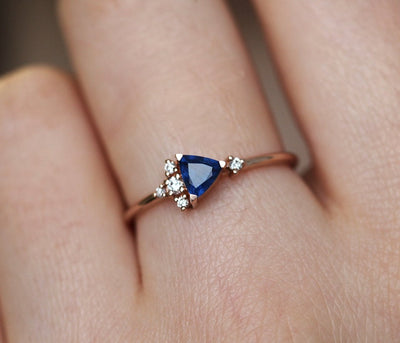 Blue triangle-cut sapphire ring with white diamond cluster