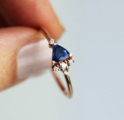 Blue triangle-cut sapphire ring with white diamond cluster