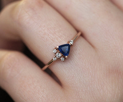 Blue triangle-cut sapphire ring with white diamond cluster