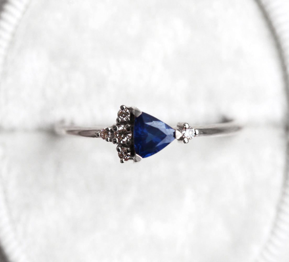 Blue triangle-cut sapphire ring with white diamond cluster