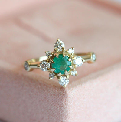 Emerald Ring featuring green emerald, diamond halo, and 14k gold band.