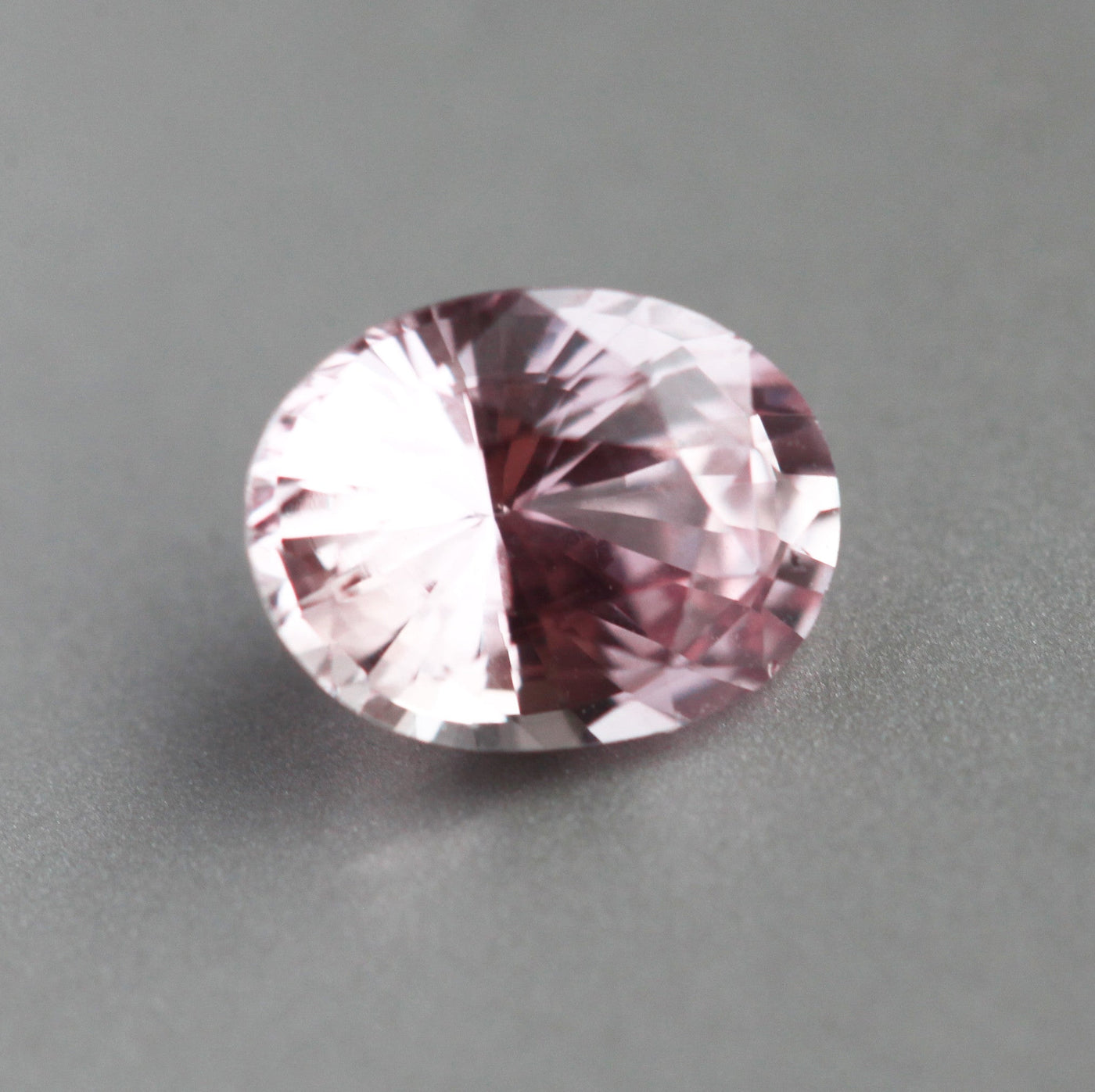 Loose oval-shaped pink orange sapphire
