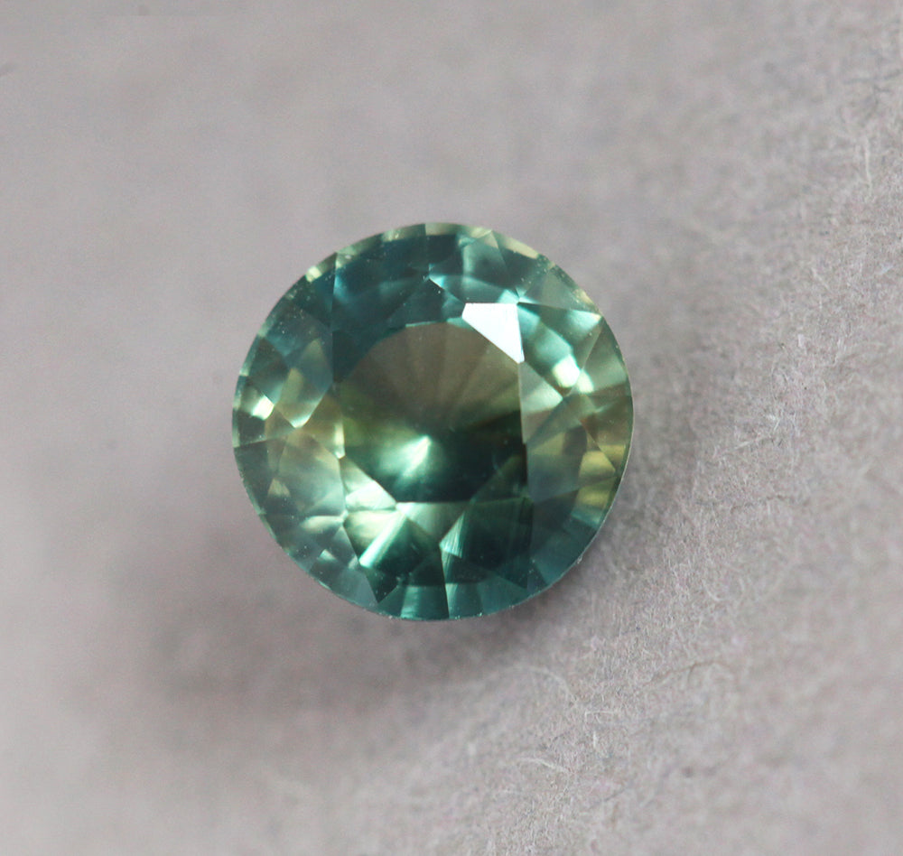 Loose round yellow green and teal sapphire