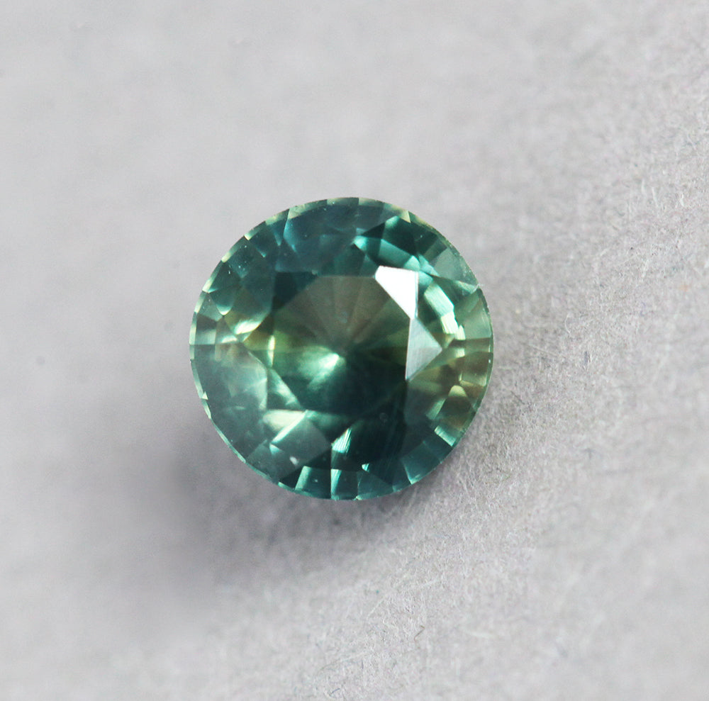 Loose round yellow green and teal sapphire