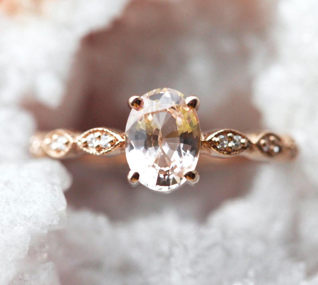 Oval-shaped peach sapphire with diamond cluster