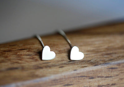 Heart-shaped gold stud earrings with dangling chain