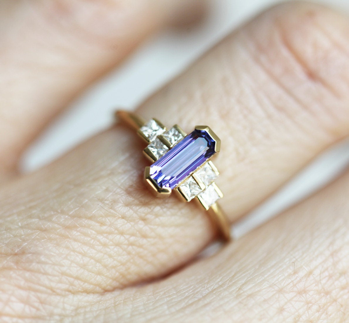 Octagon-shaped emerald-cut lavender sapphire ring with white side diamonds