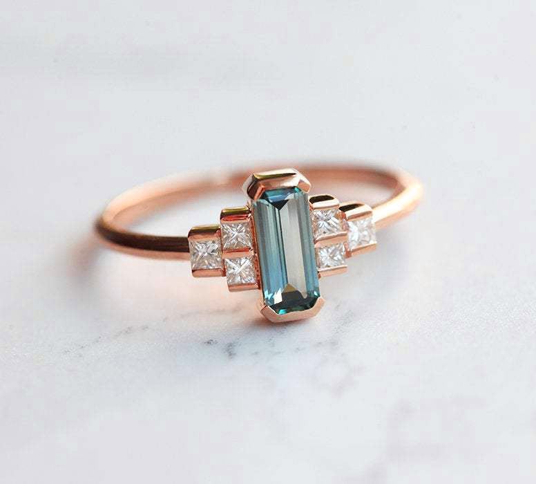 Emerald-cut teal sapphire art deco ring with white side diamonds