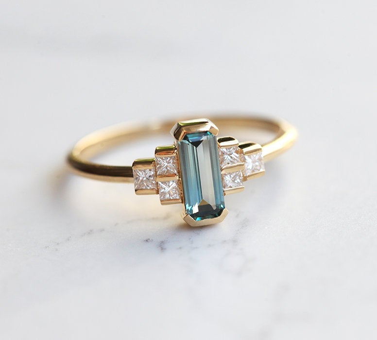 Emerald-cut teal sapphire art deco ring with white side diamonds