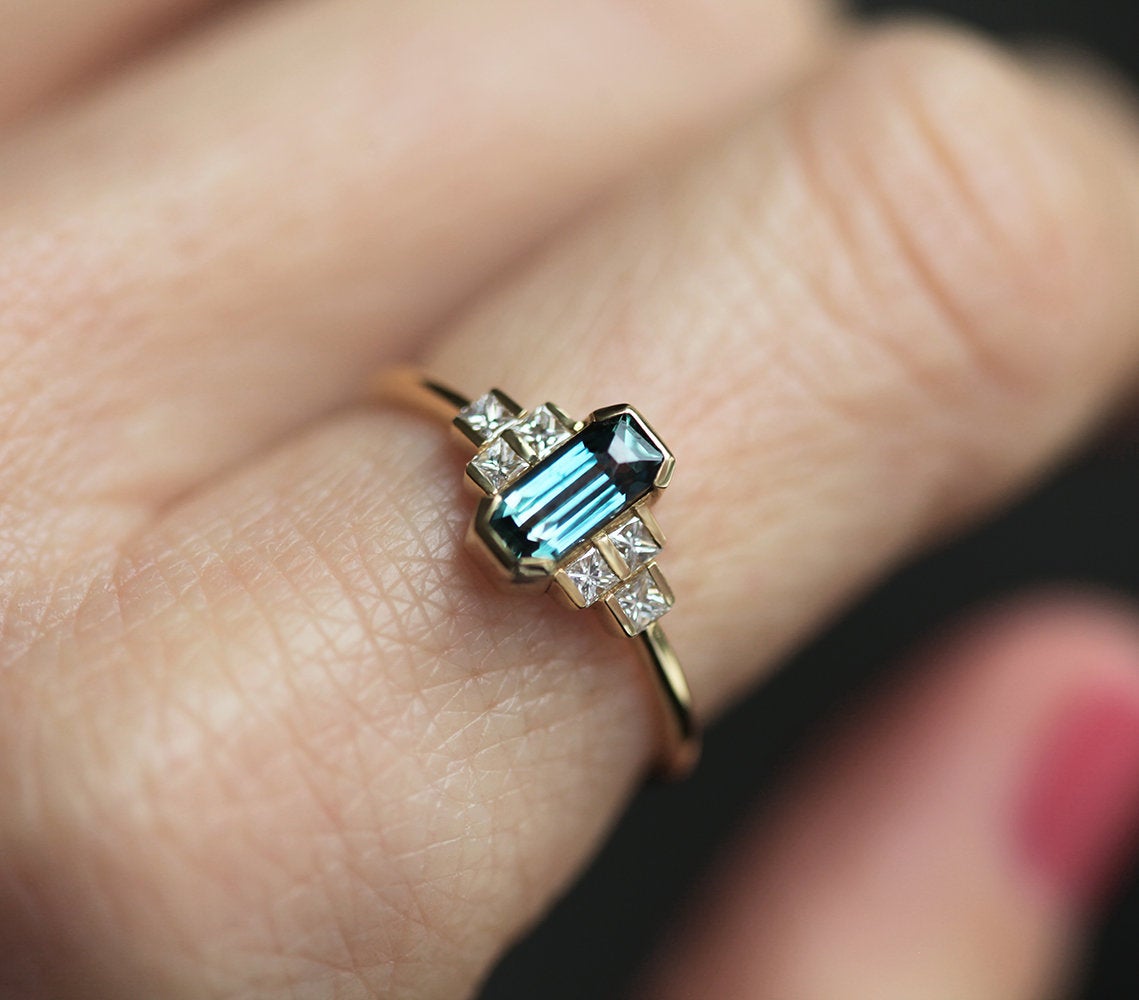 Radiant-cut blue sapphire ring with diamond cluster