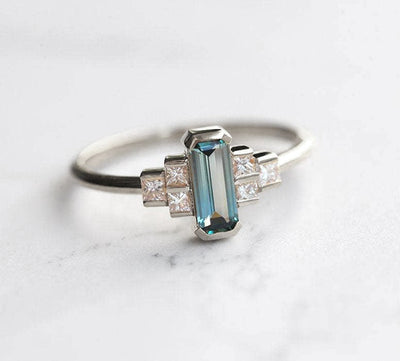 Emerald-cut teal sapphire art deco ring with white side diamonds