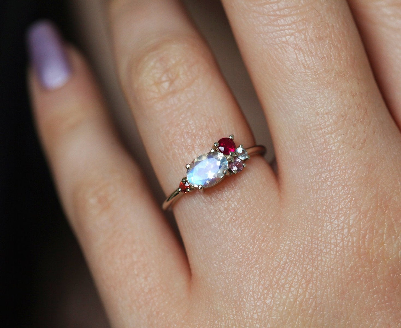 Oval-shaped white moonstone cluster ring with ruby, garnet and sapphire stones