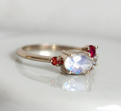 Oval-shaped white moonstone cluster ring with ruby, garnet and sapphire stones