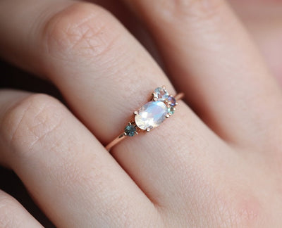 Oval-shaped white moonstone cluster ring with ruby, garnet and sapphire stones