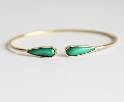 Solid gold cuffed bracelet with two pear-shaped green malachite gems