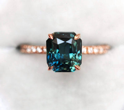 Radiant-cut teal sapphire ring with white side diamonds