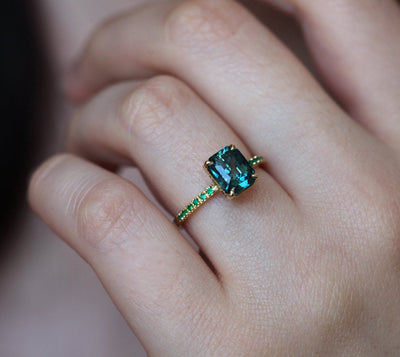 Radiant-cut teal sapphire ring with side emeralds