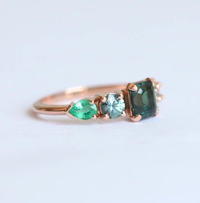 Emerald-cut sapphire cluster ring with emeralds and diamonds