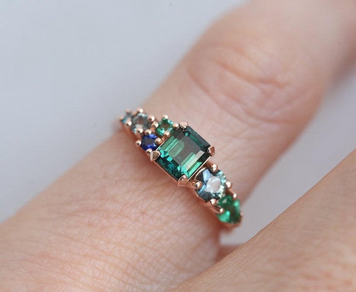 Emerald-cut sapphire cluster ring with emeralds and diamonds