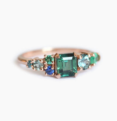 Emerald-cut sapphire cluster ring with emeralds and diamonds