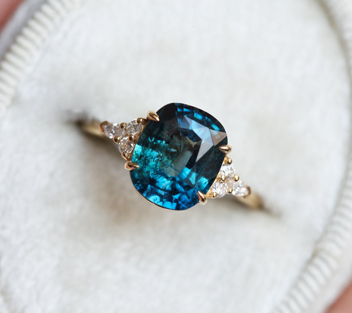 Cushion-cut blue green sapphire cluster ring with diamonds