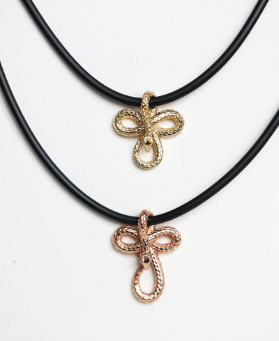 Two 14K gold snake pendant necklaces, featuring an intricate design on a sleek natural rubber cord—bold, symbolic, and effortlessly stylish.