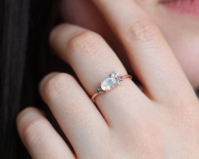 Oval moonstone cluster ring with aquamarine, sapphire, tanzanite and emerald stones