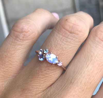 Oval moonstone cluster ring with aquamarine, sapphire, tanzanite and emerald stones