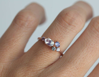 Oval moonstone cluster ring with aquamarine, sapphire, tanzanite and emerald stones