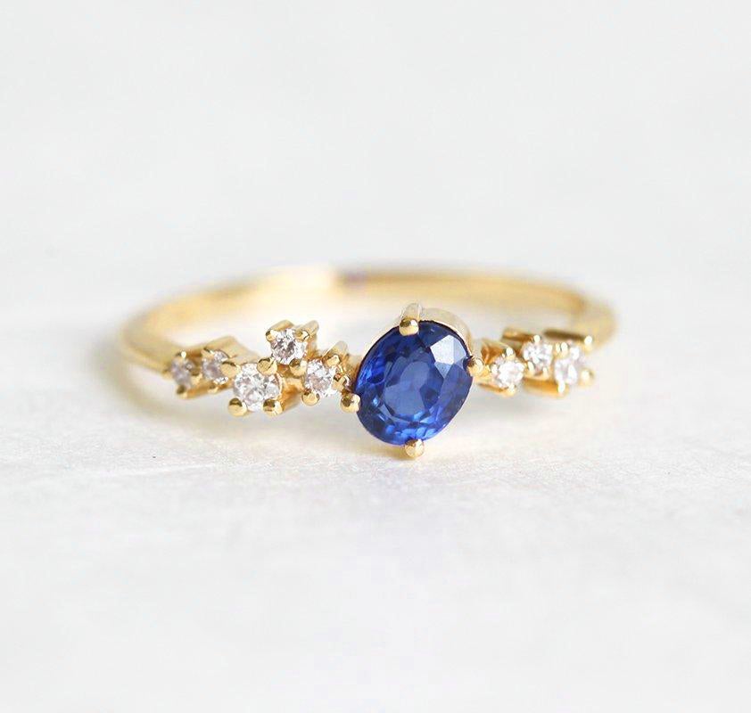 Oval-shaped blue sapphire cluster ring with diamonds