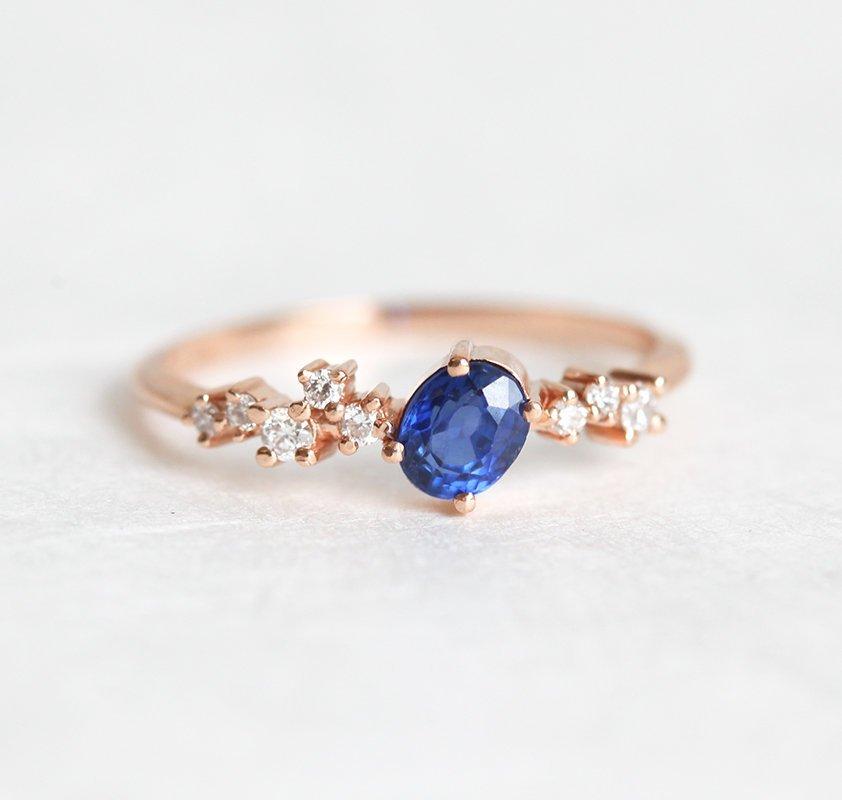 Oval-shaped blue sapphire cluster ring with diamonds
