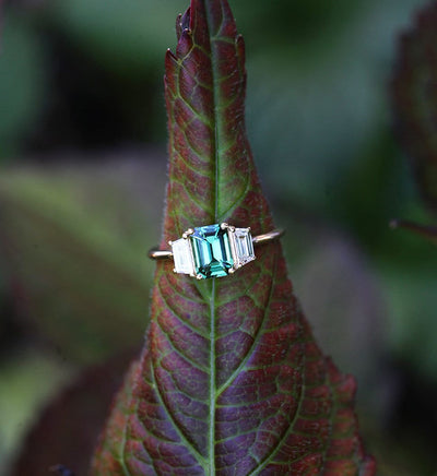 Emerald-cut blue sapphire ring with white side diamonds