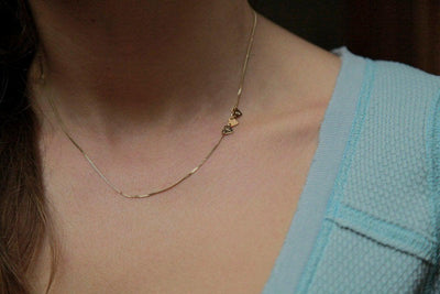 Gold necklace with three small hearts