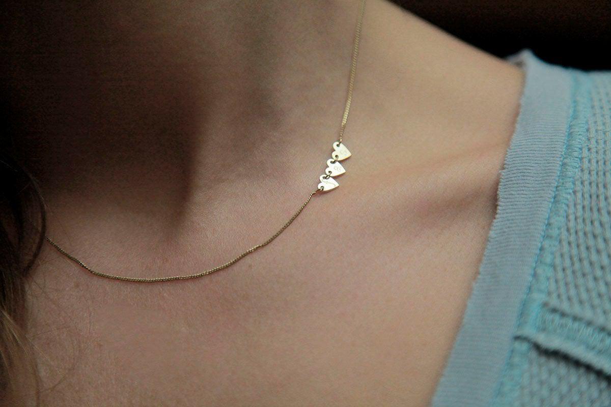 Gold necklace with three small hearts