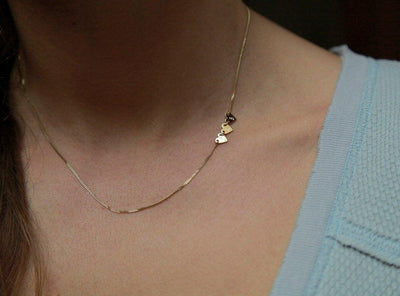 Gold necklace with three small hearts