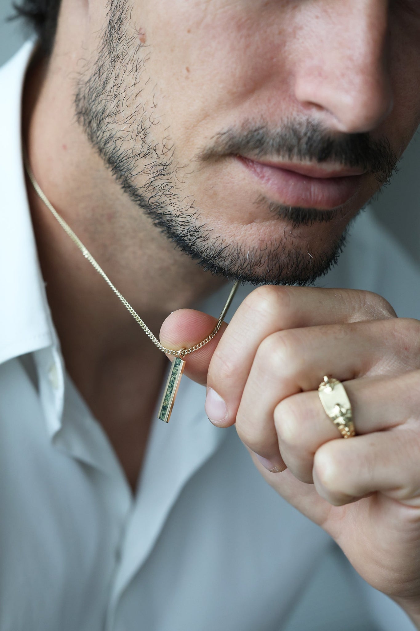 Men's emerald bar gold chain necklace on a male model