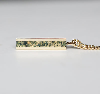 Men's bar necklace featuring a sleek 14K gold pendant with a moss agate inlay, showcasing natural green and earthy patterns on a sturdy chain.