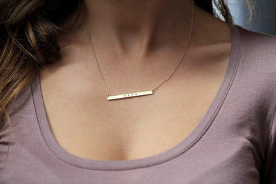 Gold bar chain necklace with four round diamonds