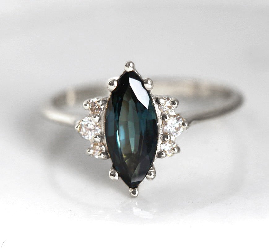 Marquise-cut teal sapphire ring with white side diamonds