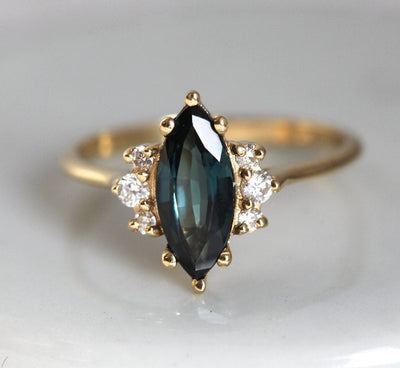 Marquise-cut teal sapphire ring with white side diamonds
