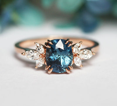 Cushion-cut blue sapphire cluster ring with white diamonds