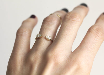 Gold horseshoe ring with white pear-shaped diamonds
